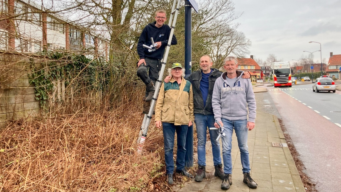 Vlaggenhouders aan lantaarnpalen in Hoogland met initiatiefnemers